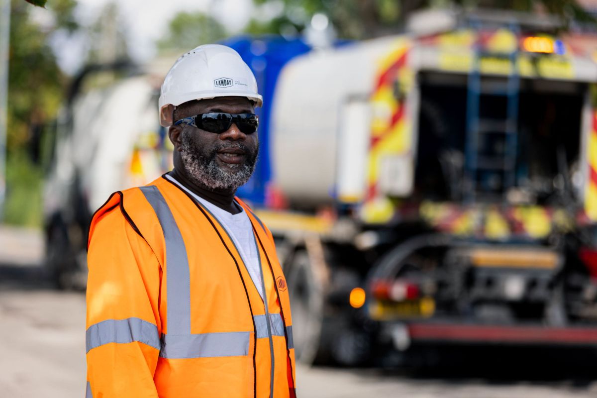 Lawday site supervisor in hi-vis and hard hat, tanker vehicle in the background