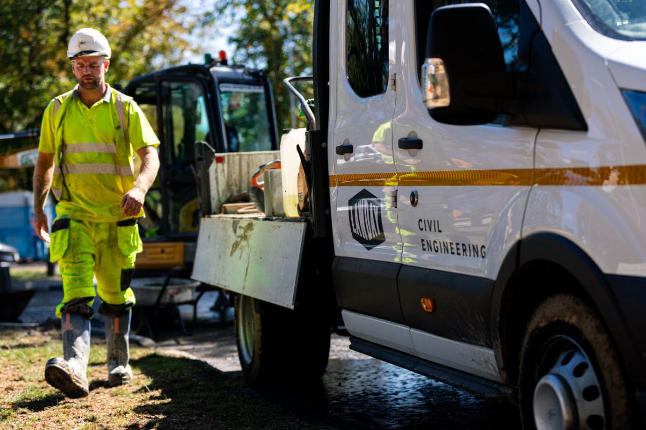 Lawday operative walking beside a liveried site van carrying tools